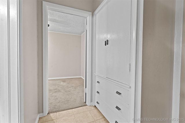 1015 NW Maxwell, Ardmore, OK 73401 - corridor featuring a textured ceiling, light carpet, and light tile patterned flooring