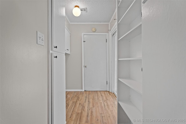 1015 NW Maxwell, Ardmore, OK 73401 - corridor featuring light wood-style floors, a textured ceiling, and ornamental molding