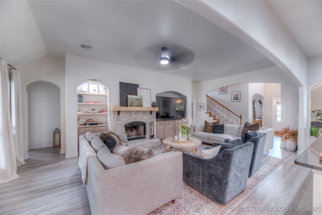 7349 E 119th Pl S, Bixby, OK 74008 - living area with a ceiling fan, light wood-style floors, stairway, arched walkways, and a fireplace with raised hearth
