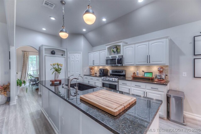 7349 E 119th Pl S, Bixby, OK 74008 - kitchen featuring appliances with stainless steel finishes, light wood-style floors, white cabinets, backsplash, and lofted ceiling