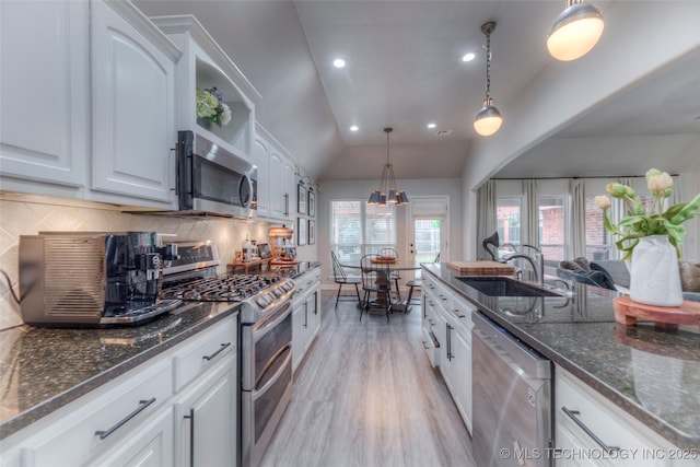 7349 E 119th Pl S, Bixby, OK 74008 - kitchen with stainless steel appliances, white cabinetry, backsplash, vaulted ceiling, and light wood-style flooring