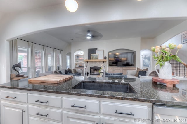 7349 E 119th Pl S, Bixby, OK 74008 - kitchen with open floor plan, arched walkways, a fireplace, and white cabinets