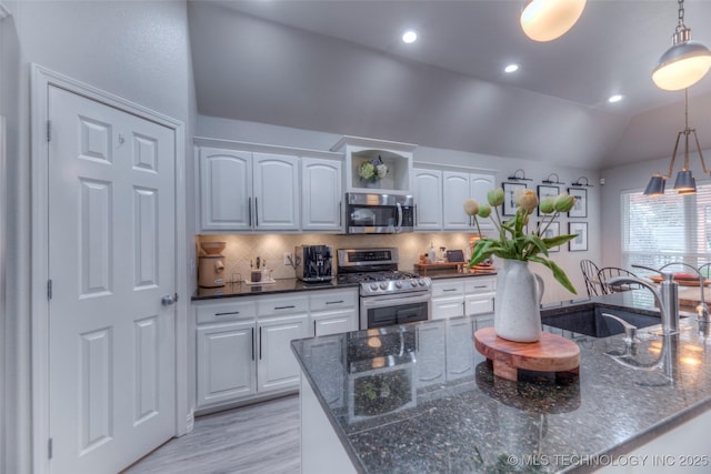 7349 E 119th Pl S, Bixby, OK 74008 - kitchen with stainless steel appliances, white cabinetry, vaulted ceiling, pendant lighting, and tasteful backsplash