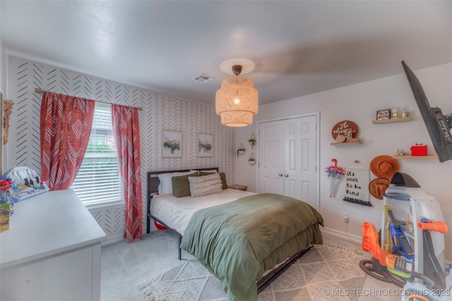 7349 E 119th Pl S, Bixby, OK 74008 - bedroom with wallpapered walls, an accent wall, light colored carpet, and a closet