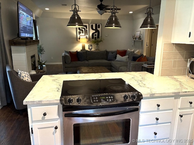 417292 E 1145th Rd, Eufaula, OK 74432 - kitchen featuring appliances with stainless steel finishes, a fireplace, dark wood-type flooring, white cabinets, and ceiling fan