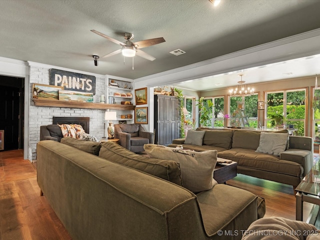 105 Quail Creek Ln, Skiatook, OK 74070 - living room featuring a ceiling fan, a brick fireplace, a textured ceiling, crown molding, and wood finished floors