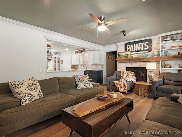 105 Quail Creek Ln, Skiatook, OK 74070 - living area with light wood finished floors, a ceiling fan, crown molding, and a fireplace