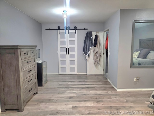 76654 S 4695, Stilwell, OK 74960 - bedroom with a barn door and light wood-type flooring