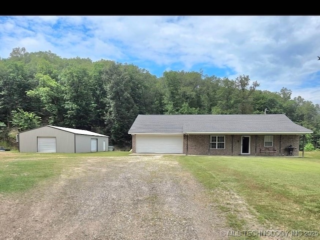 76654 S 4695, Stilwell, OK 74960 - view of front of property with driveway, a front yard, an outdoor structure, a detached garage, and brick siding