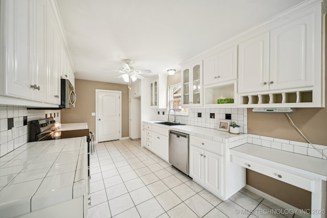 106 E 21st St, Owasso, OK 74055 - kitchen with appliances with stainless steel finishes, tile countertops, and tasteful backsplash