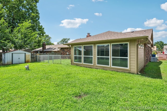 106 E 21st St, Owasso, OK 74055 - rear view of property featuring a fenced backyard, a storage shed, a shingled roof, and a chimney