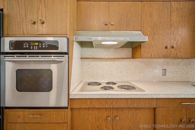 1234 S 101st E Ave, Tulsa, OK 74128 - kitchen with stainless steel oven, custom exhaust hood, white electric stovetop, backsplash, and light countertops