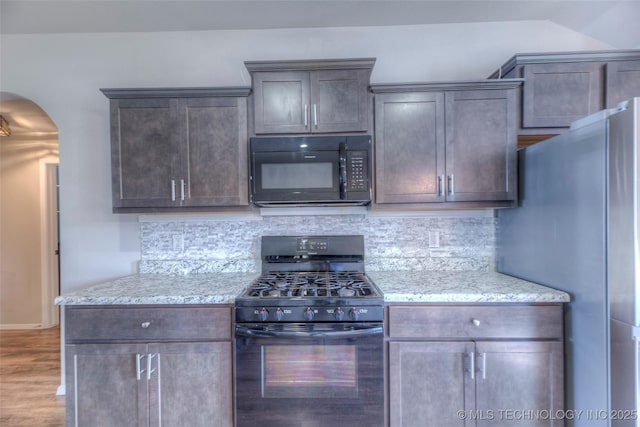 3711 S 151st E Ave, Tulsa, OK 74134 - kitchen featuring black appliances, tasteful backsplash, wood finished floors, and light stone counters