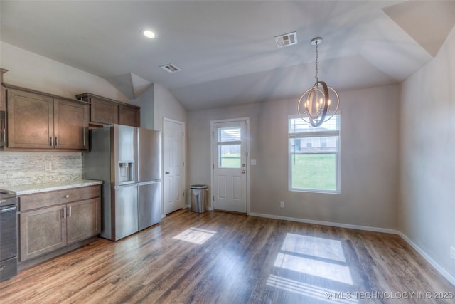 3711 S 151st E Ave, Tulsa, OK 74134 - kitchen featuring stainless steel fridge with ice dispenser, vaulted ceiling, a chandelier, light wood-style flooring, and decorative backsplash