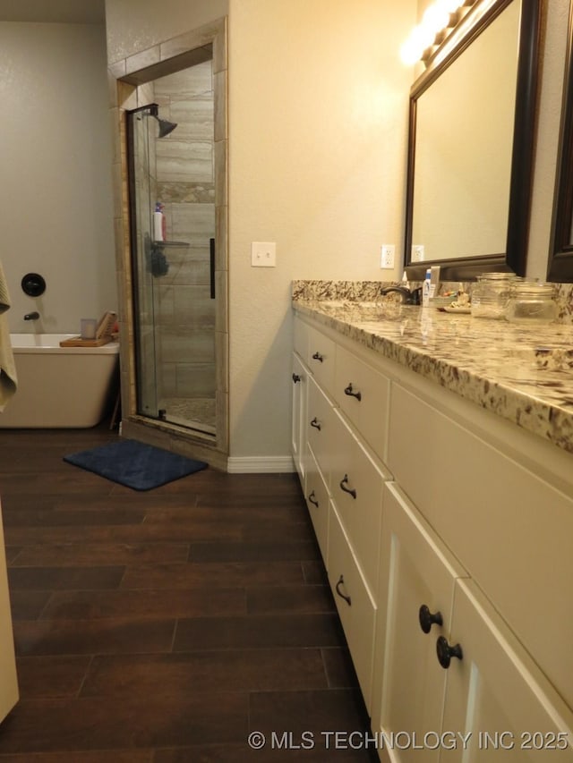 504 Blocker Rd, Mcalester, OK 74501 - bathroom with vanity, wood finished floors, a stall shower, and a tub to relax in