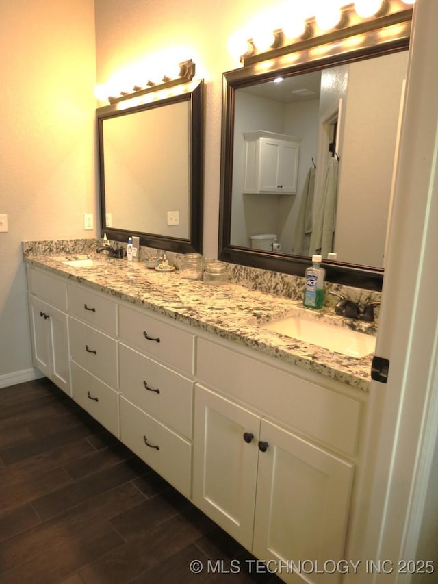504 Blocker Rd, Mcalester, OK 74501 - bathroom featuring double vanity and wood finished floors