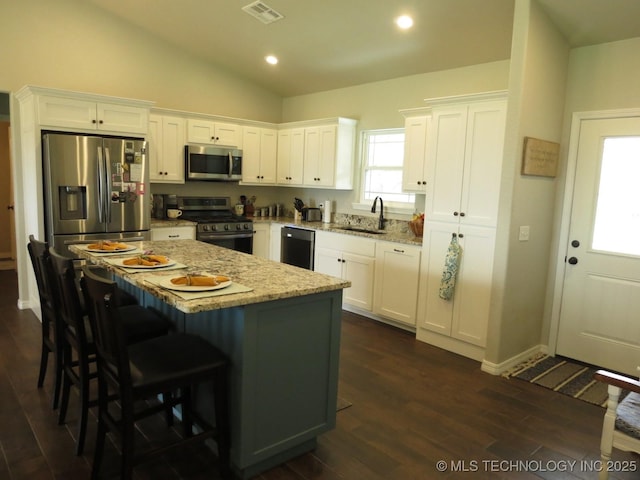 504 Blocker Rd, Mcalester, OK 74501 - kitchen featuring stainless steel appliances, white cabinets, a kitchen island, vaulted ceiling, and recessed lighting