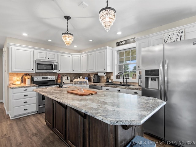16145 Ew 255 Rd, Nowata, OK 74048 - kitchen with appliances with stainless steel finishes, a chandelier, dark wood-style flooring, white cabinetry, and recessed lighting