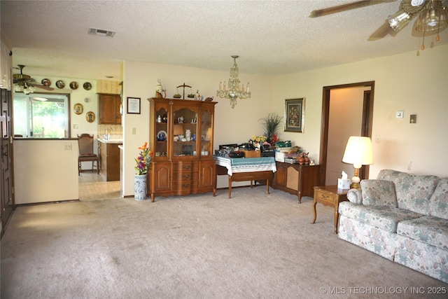 710 N 14th St, Henryetta, OK 74437 - living area with a ceiling fan, light colored carpet, a textured ceiling, and a chandelier