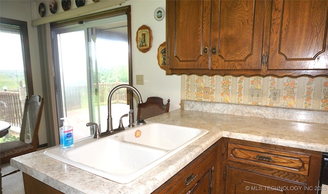 710 N 14th St, Henryetta, OK 74437 - kitchen featuring light countertops, brown cabinets, and decorative backsplash