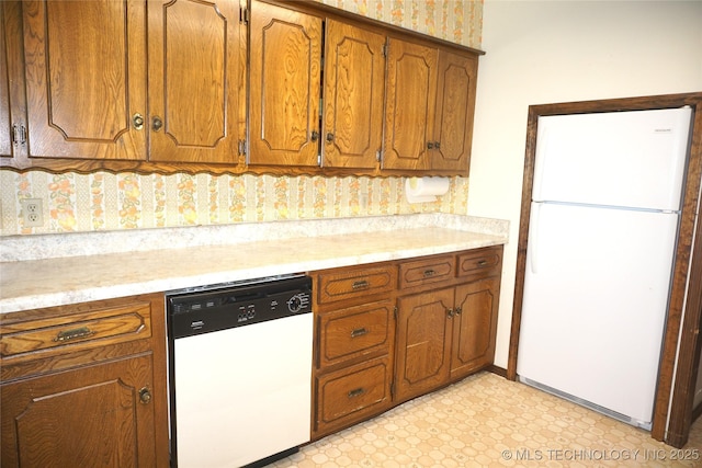 710 N 14th St, Henryetta, OK 74437 - kitchen with white appliances, brown cabinetry, and light countertops