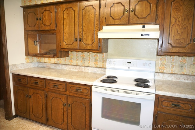 710 N 14th St, Henryetta, OK 74437 - kitchen featuring white range with electric stovetop, custom range hood, light countertops, and brown cabinets