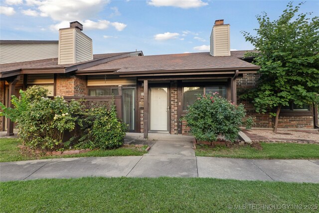 11030 E 11th Pl Unit 4A, Tulsa, OK 74128 - view of front of property featuring a chimney and brick siding