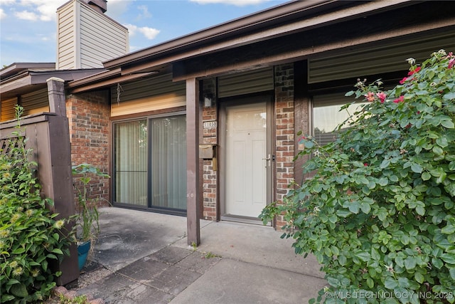 11030 E 11th Pl Unit 4A, Tulsa, OK 74128 - property entrance with brick siding and a chimney