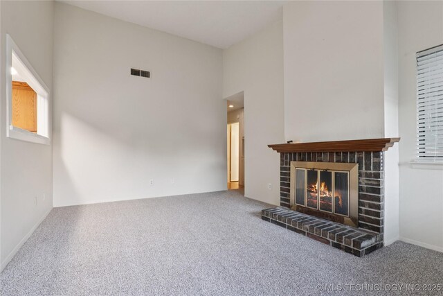 11030 E 11th Pl Unit 4A, Tulsa, OK 74128 - unfurnished living room featuring carpet floors, a fireplace, and a high ceiling