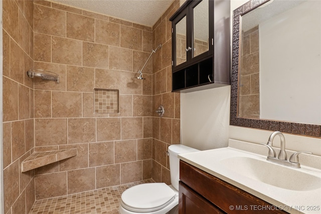 11030 E 11th Pl Unit 4A, Tulsa, OK 74128 - bathroom with a tile shower, vanity, and a textured ceiling