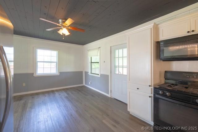 604 N N W, Konawa, OK 74849 - kitchen with black appliances, wood ceiling, wood finished floors, a ceiling fan, and white cabinetry