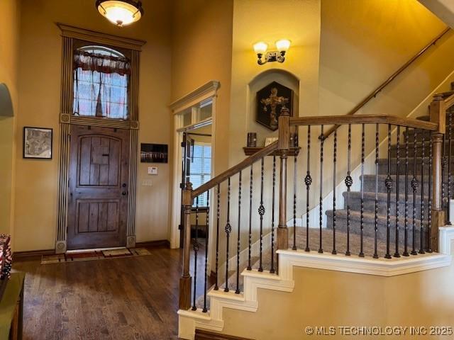 2511 E 138th St S, Bixby, OK 74008 - entrance foyer featuring a towering ceiling, arched walkways, stairway, and wood finished floors