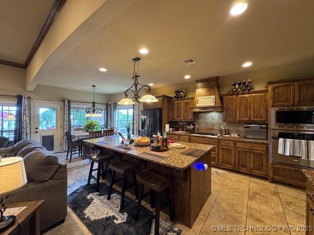 2511 E 138th St S, Bixby, OK 74008 - kitchen with stainless steel appliances, tasteful backsplash, open floor plan, recessed lighting, and a breakfast bar area