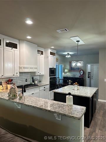 1821 W Lincoln St N, Broken Arrow, OK 74012 - kitchen featuring a center island, oven, a peninsula, white cabinetry, and wood finished floors