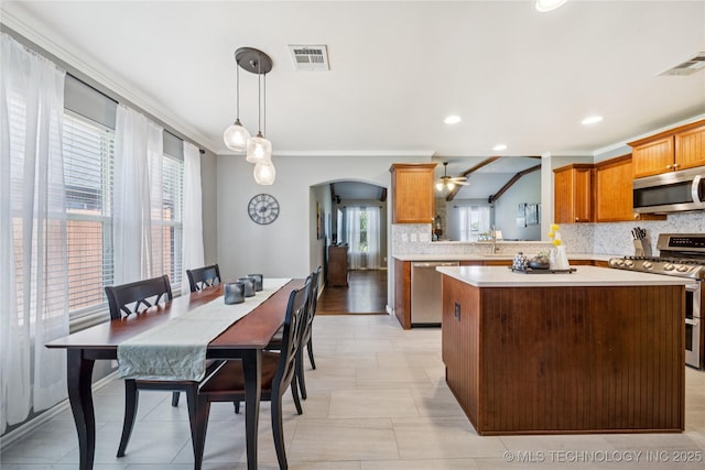 11710 S Willow St, Jenks, OK 74037 - kitchen with stainless steel appliances, decorative backsplash, healthy amount of natural light, arched walkways, and recessed lighting