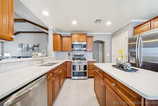 11710 S Willow St, Jenks, OK 74037 - kitchen featuring stainless steel appliances, crown molding, arched walkways, light countertops, and backsplash