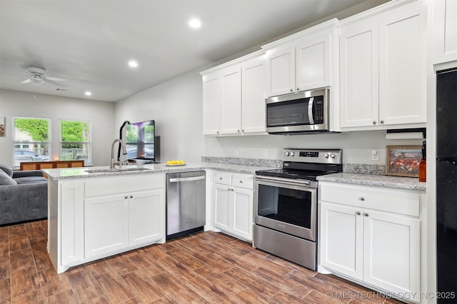 1325 Houston, Durant, OK 74701 - kitchen with stainless steel appliances, a peninsula, a ceiling fan, open floor plan, and white cabinetry