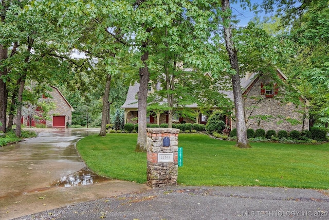 22765 S Red Oak Dr, Claremore, OK 74019 - obstructed view of property featuring a front yard, a garage, driveway, and stone siding