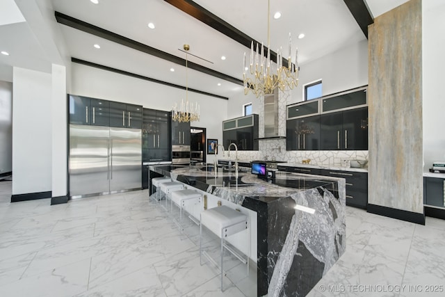 1226 W 109th Pl S, Jenks, OK 74037 - kitchen featuring a chandelier, built in refrigerator, light marble finish floors, a large island with sink, and decorative backsplash