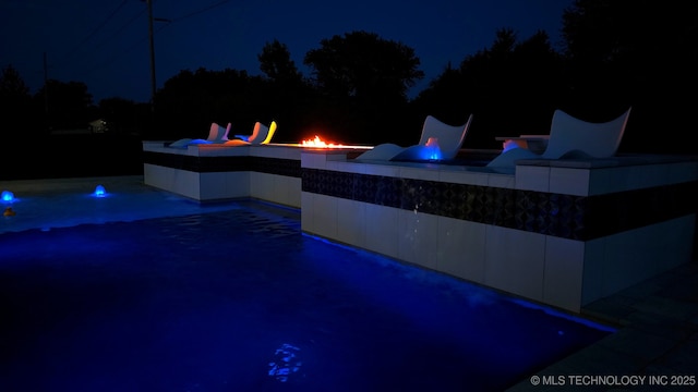 1226 W 109th Pl S, Jenks, OK 74037 - pool at twilight featuring a fire pit, an outdoor pool, and a patio