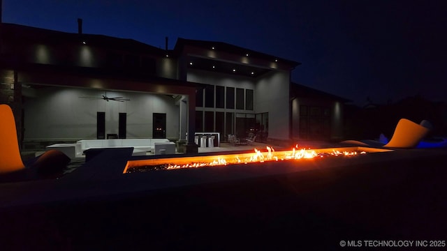 1226 W 109th Pl S, Jenks, OK 74037 - back of house at twilight with a fire pit, ceiling fan, and a patio