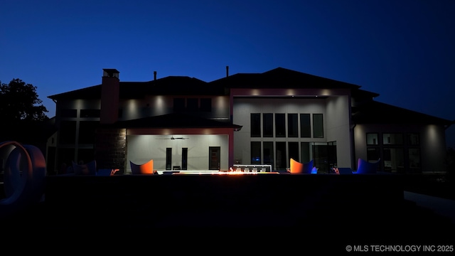 1226 W 109th Pl S, Jenks, OK 74037 - back of house at night featuring a chimney