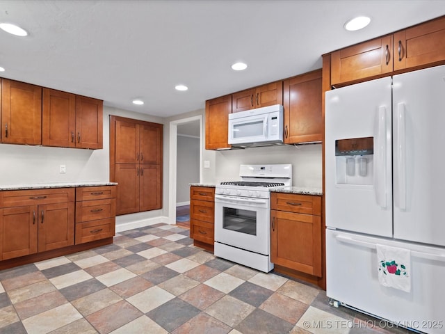 1322 Boundary Ave, Pawhuska, OK 74056 - kitchen with white appliances, brown cabinetry, and recessed lighting