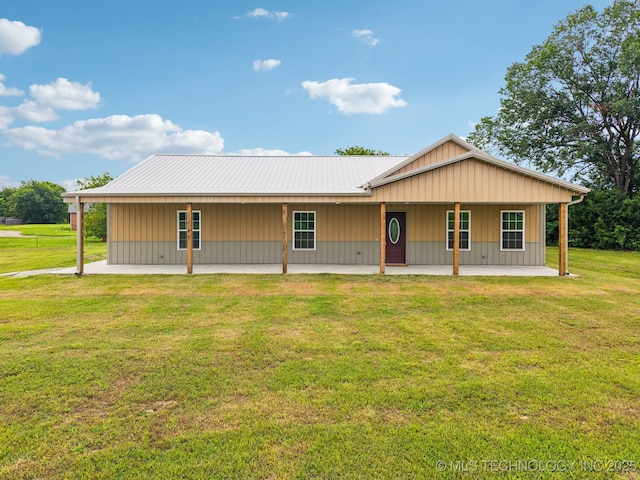 1102 W Main St, Beggs, OK 74421 - view of front of house with a patio area, a front lawn, and a metal roof