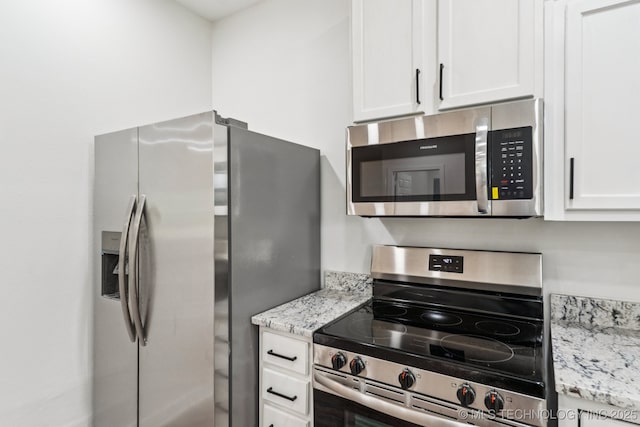 1102 W Main St, Beggs, OK 74421 - kitchen featuring appliances with stainless steel finishes, white cabinets, and light stone counters