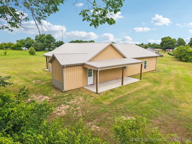 1102 W Main St, Beggs, OK 74421 - back of property with a patio area, a lawn, and a metal roof