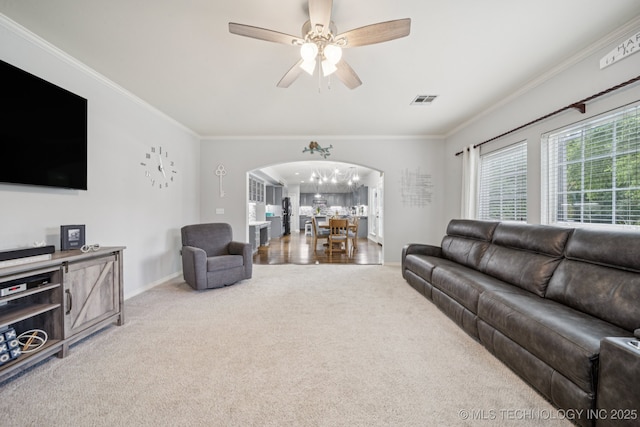 3701 W Dallas St, Broken Arrow, OK 74012 - carpeted living room featuring arched walkways, crown molding, ceiling fan, and a chandelier