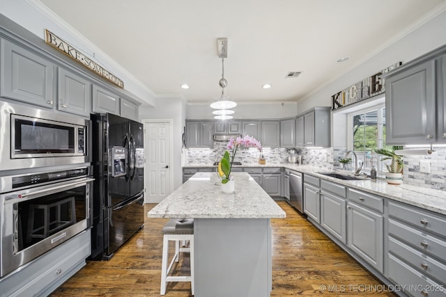 3701 W Dallas St, Broken Arrow, OK 74012 - kitchen featuring gray cabinetry, appliances with stainless steel finishes, ornamental molding, a center island, and decorative backsplash