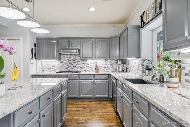 3701 W Dallas St, Broken Arrow, OK 74012 - kitchen with gray cabinetry, under cabinet range hood, stainless steel appliances, decorative backsplash, and ornamental molding