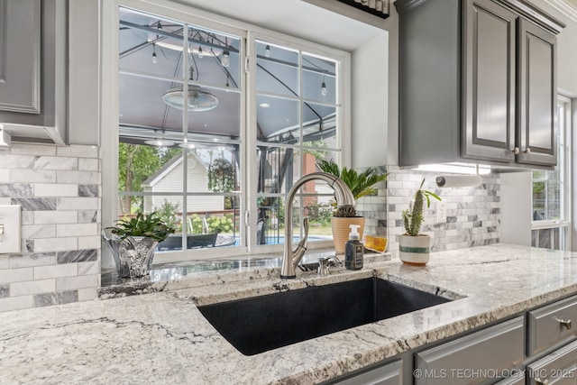 3701 W Dallas St, Broken Arrow, OK 74012 - kitchen with gray cabinetry, decorative backsplash, and light stone countertops